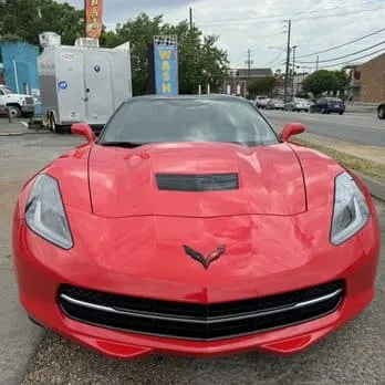 Freshly detailed red Chevrolet Corvette outside HeadLampChamp